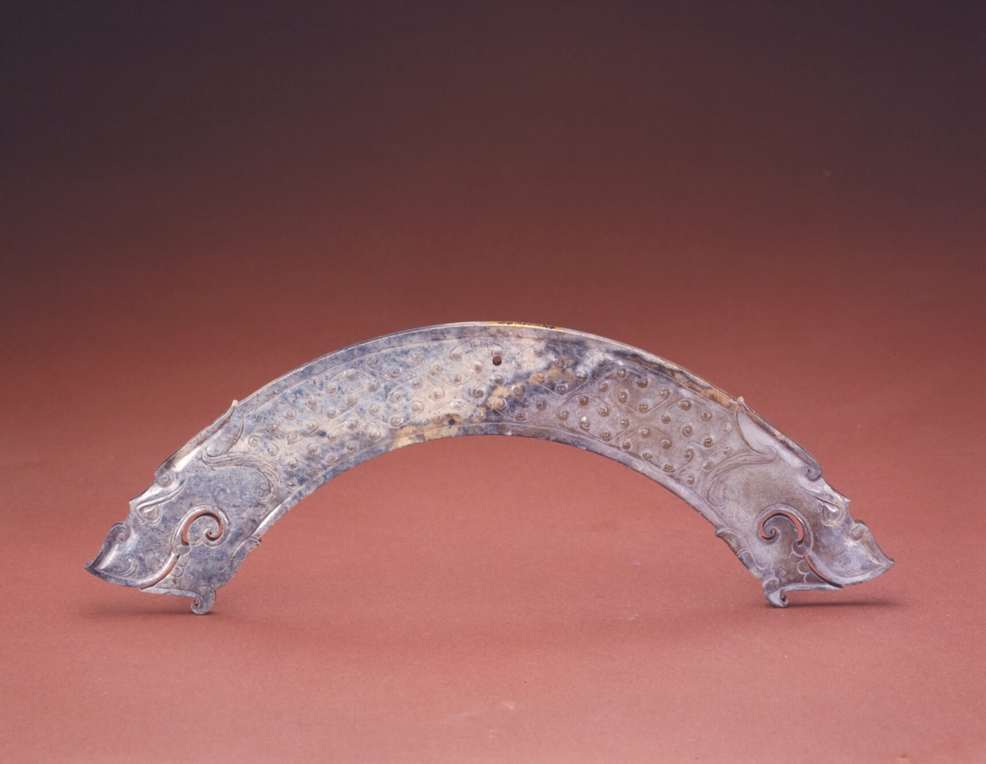 Huang (pieza de jade en forma <br />
de arco que se utilizaba como <br />
colgante) tallado con cabezas <br />
de dragón del Periodo de los <br />
Reinos Combatientes